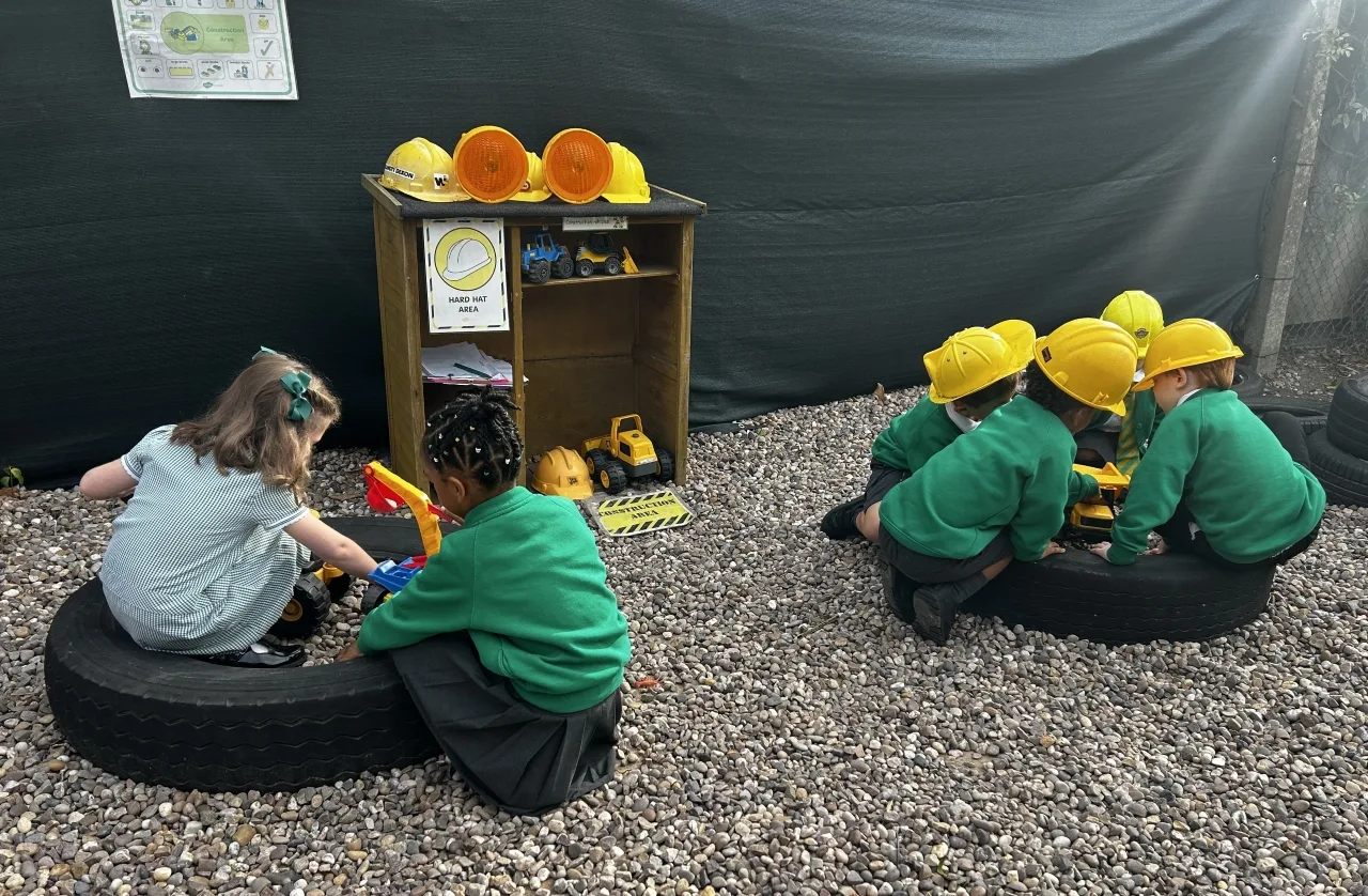 Wooburn Green Primary School pupils playing with toy diggers in the outdoor construction area